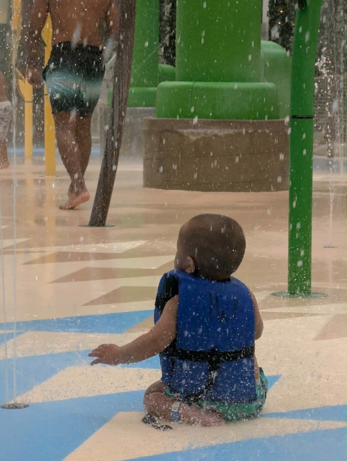 Parker sitting in the splash pad area at Island Water Park