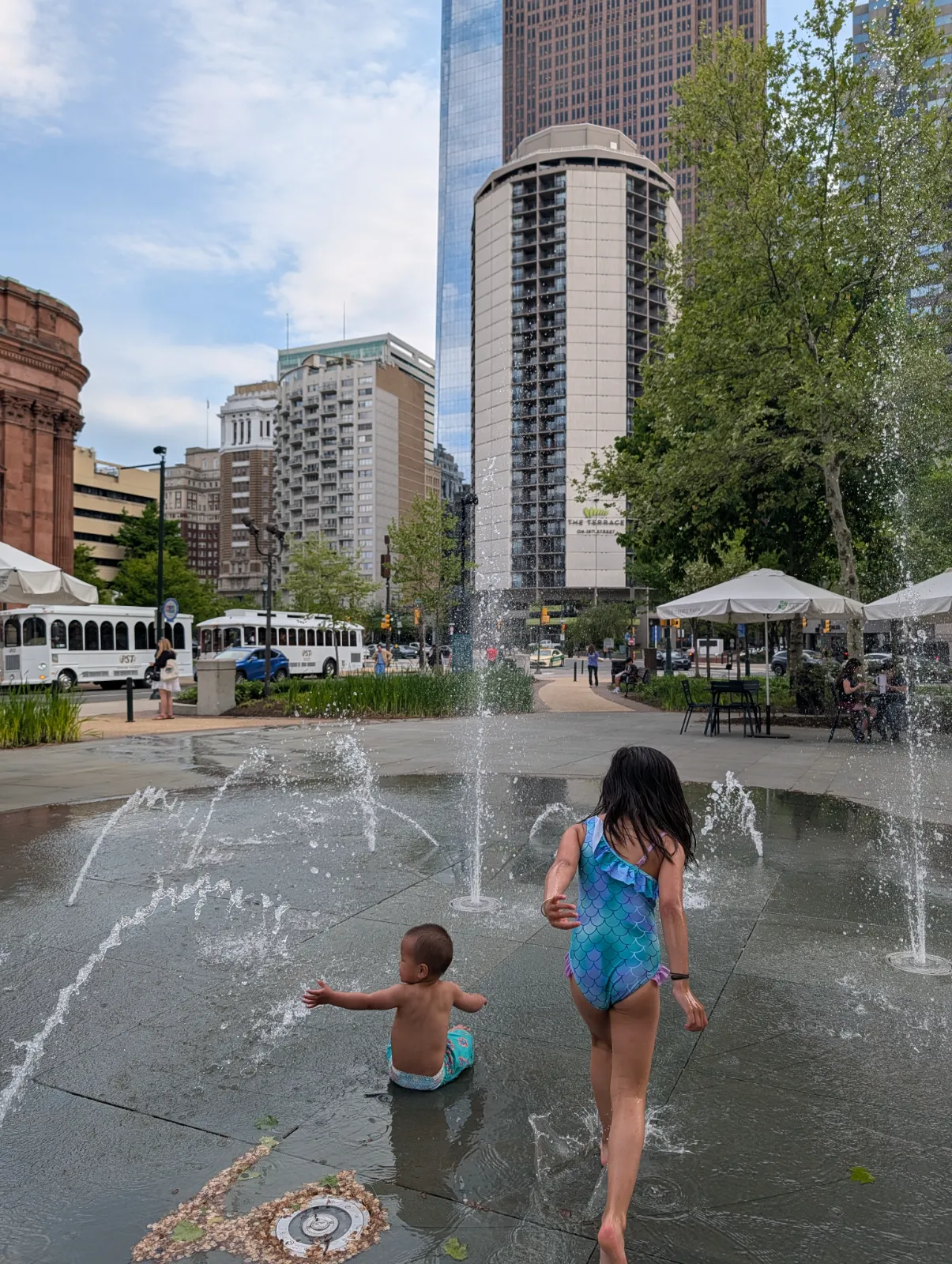 Children playing in a city water fountain near the museum district