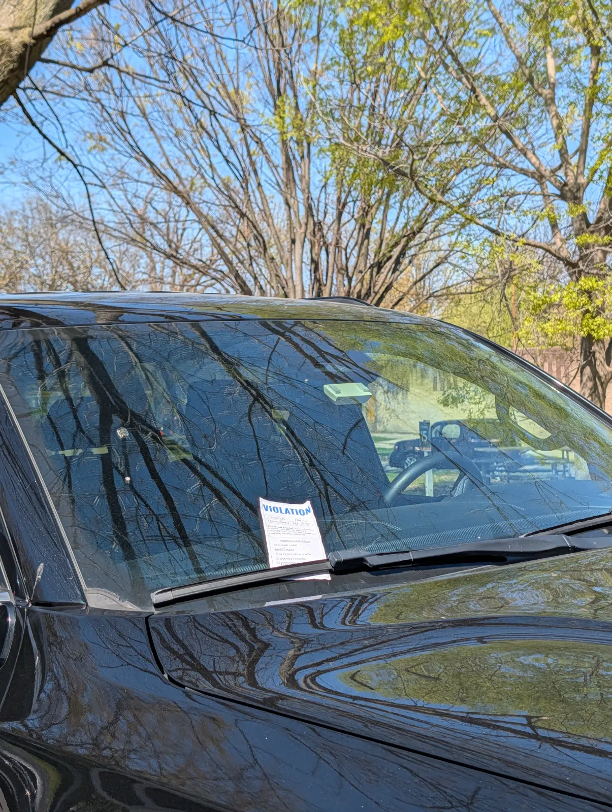 A car with a parking ticket on the windshield