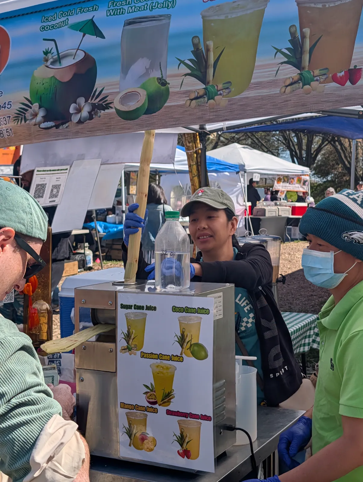 Fresh sugarcane being pressed through a machine with flavor options displayed