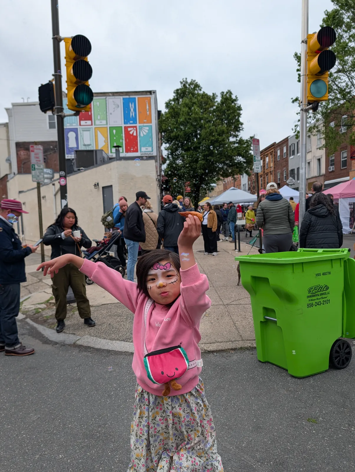 A joyful child celebrating at Flavors on the Avenue with playful face paint and vibrant attire