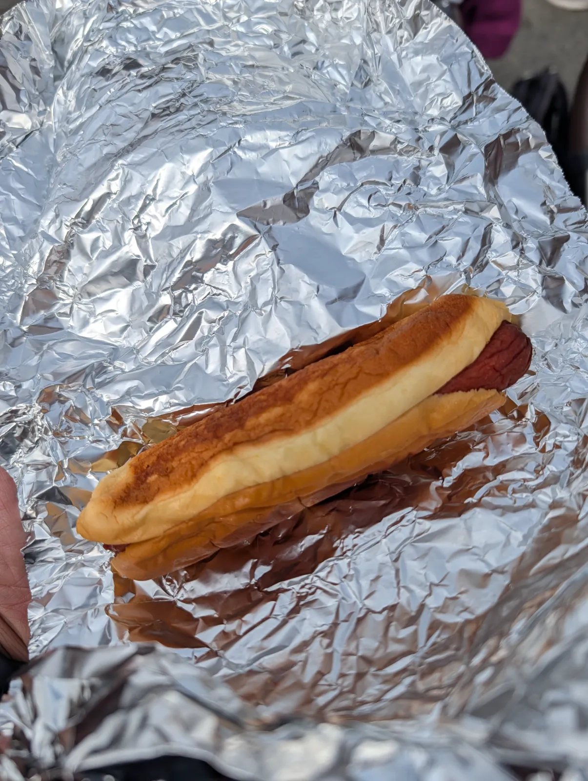A $1 hot dog wrapped in foil at Flavors on the Avenue