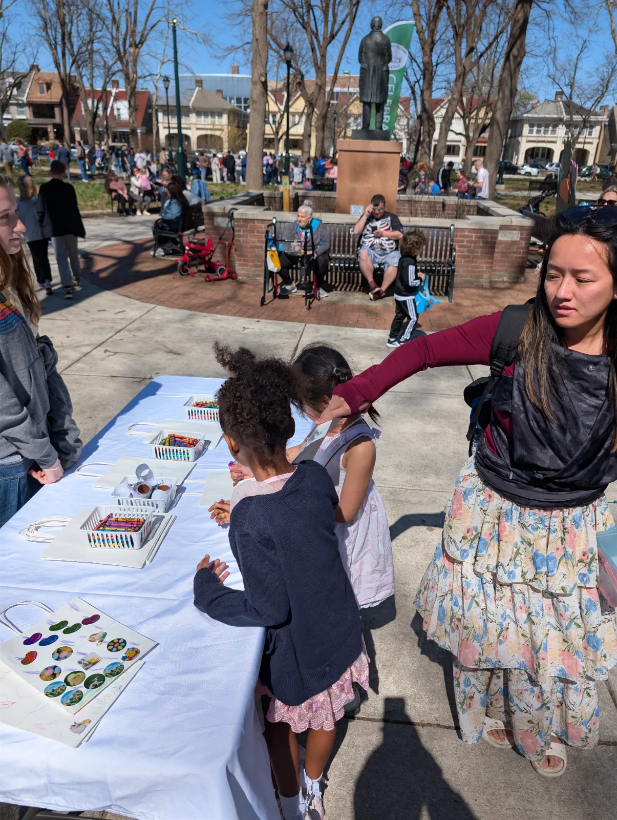 Children coloring at a decorated activity table at an outdoor Easter event