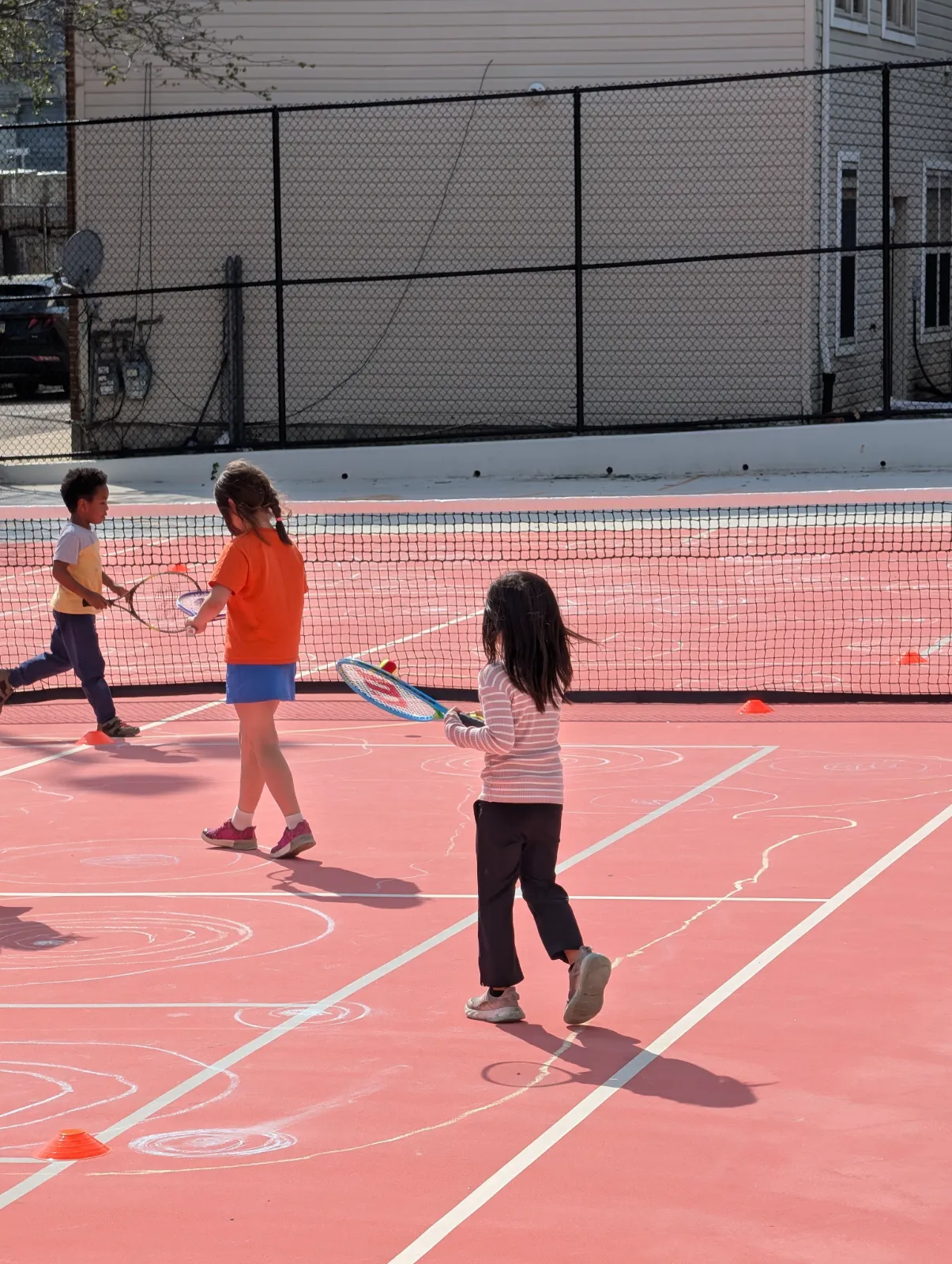 Charlotte holding her Wilson tennis racket on the court