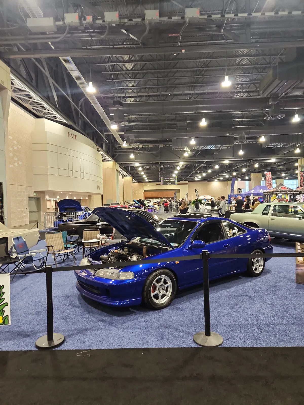 A vibrant blue modified car on display at the Philadelphia Auto Show
