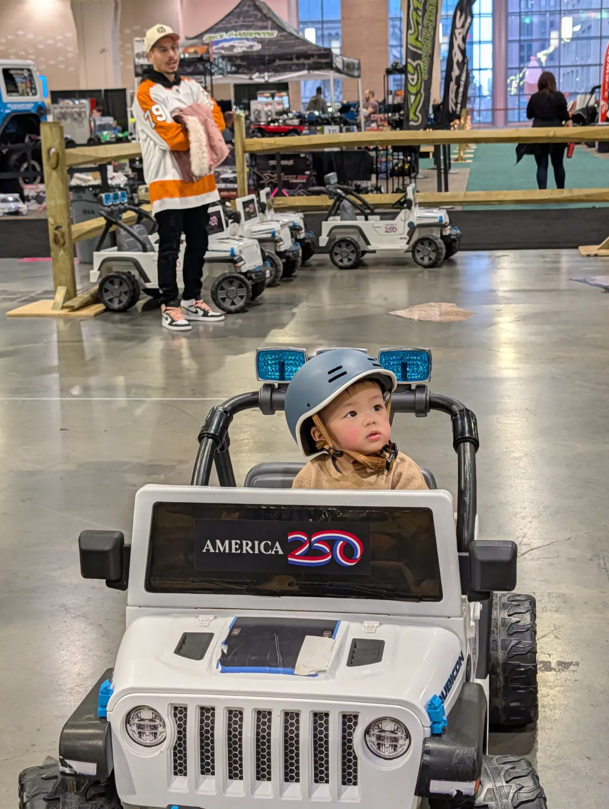 Parker grinning in a mini Jeep wearing a helmet at the Philadelphia Auto Show