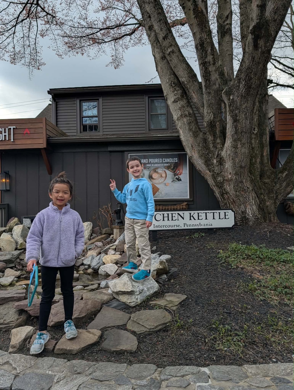 Charlotte and friend in front of the Kitchen Kettle Village sign