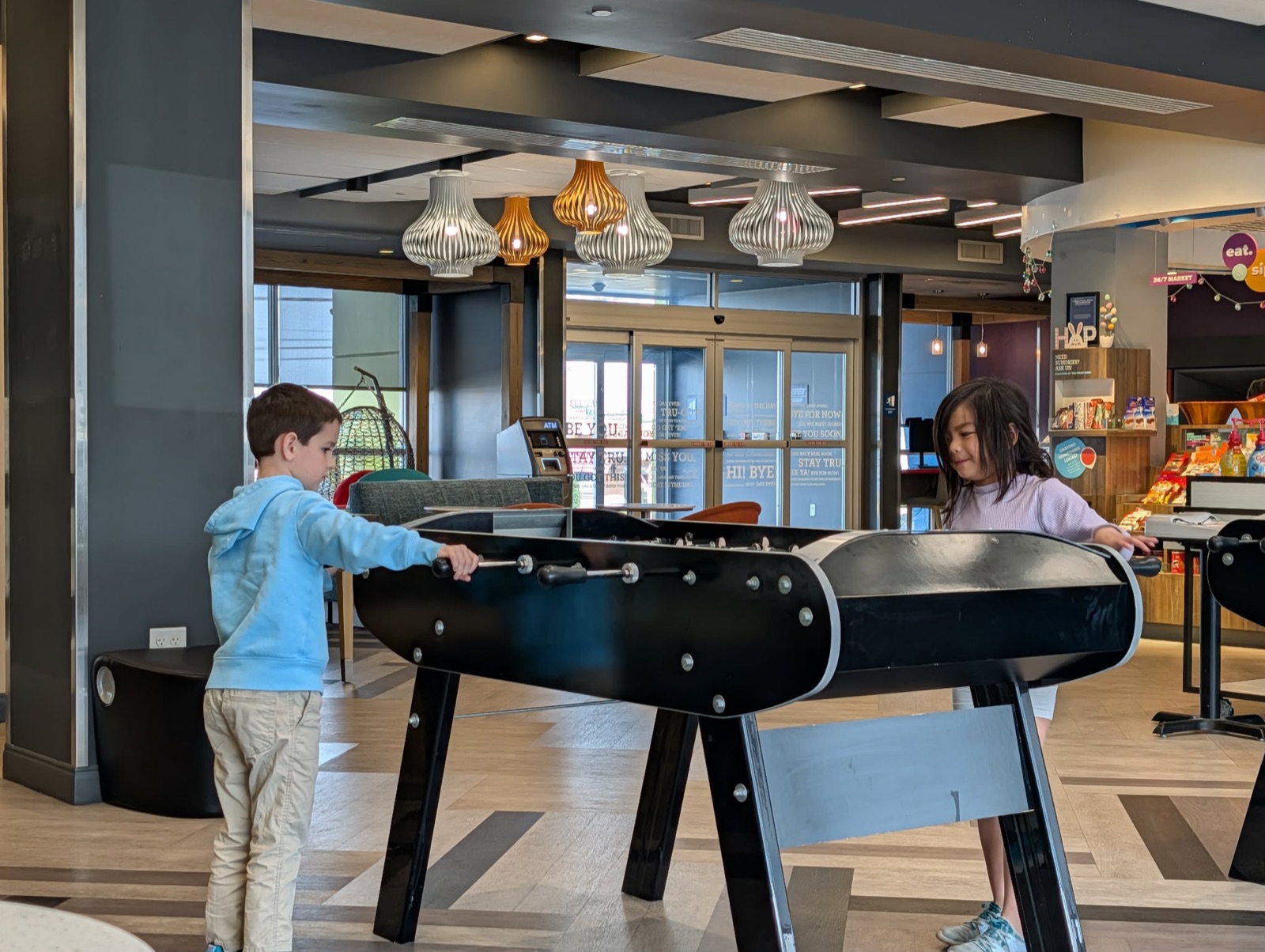 Kids playing foosball in the Tru by Hilton lobby