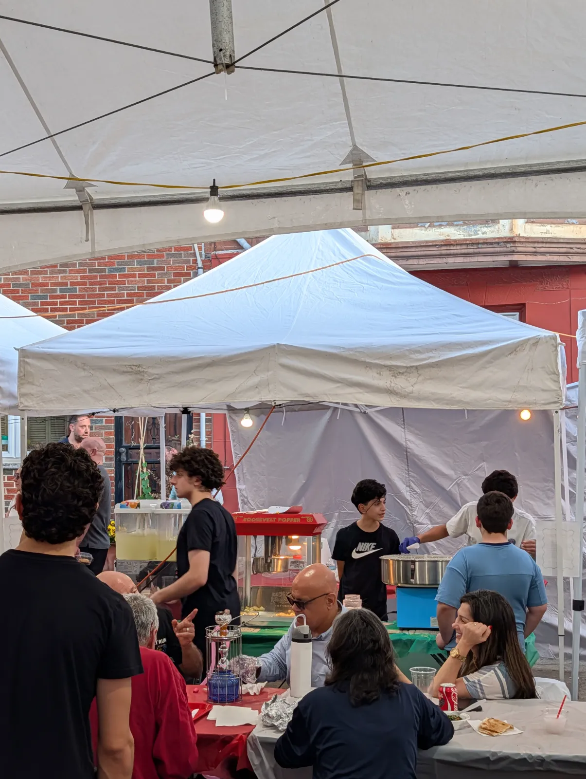 Families at the Lebanese Festival under a large tent with food vendors serving visitors
