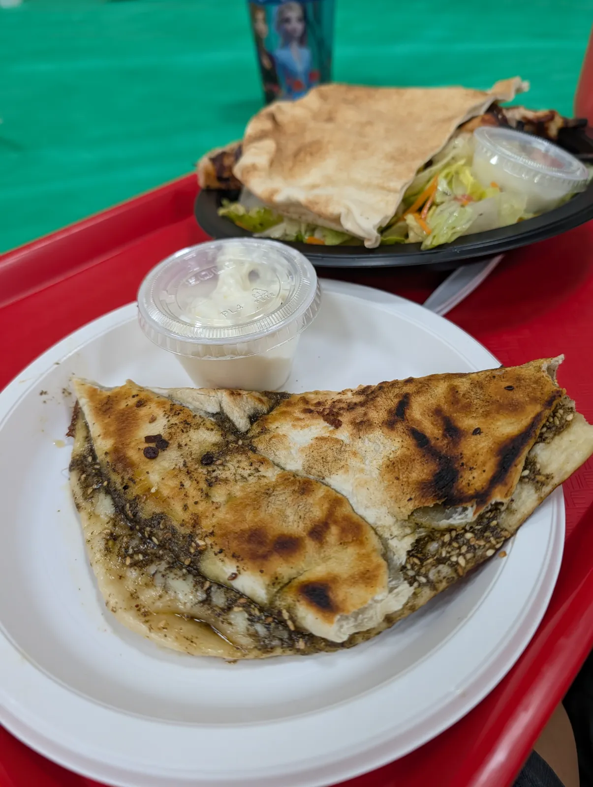 A plate of flatbread filled with herbs and spices served with fresh salad and dipping sauce at the Lebanese Festival