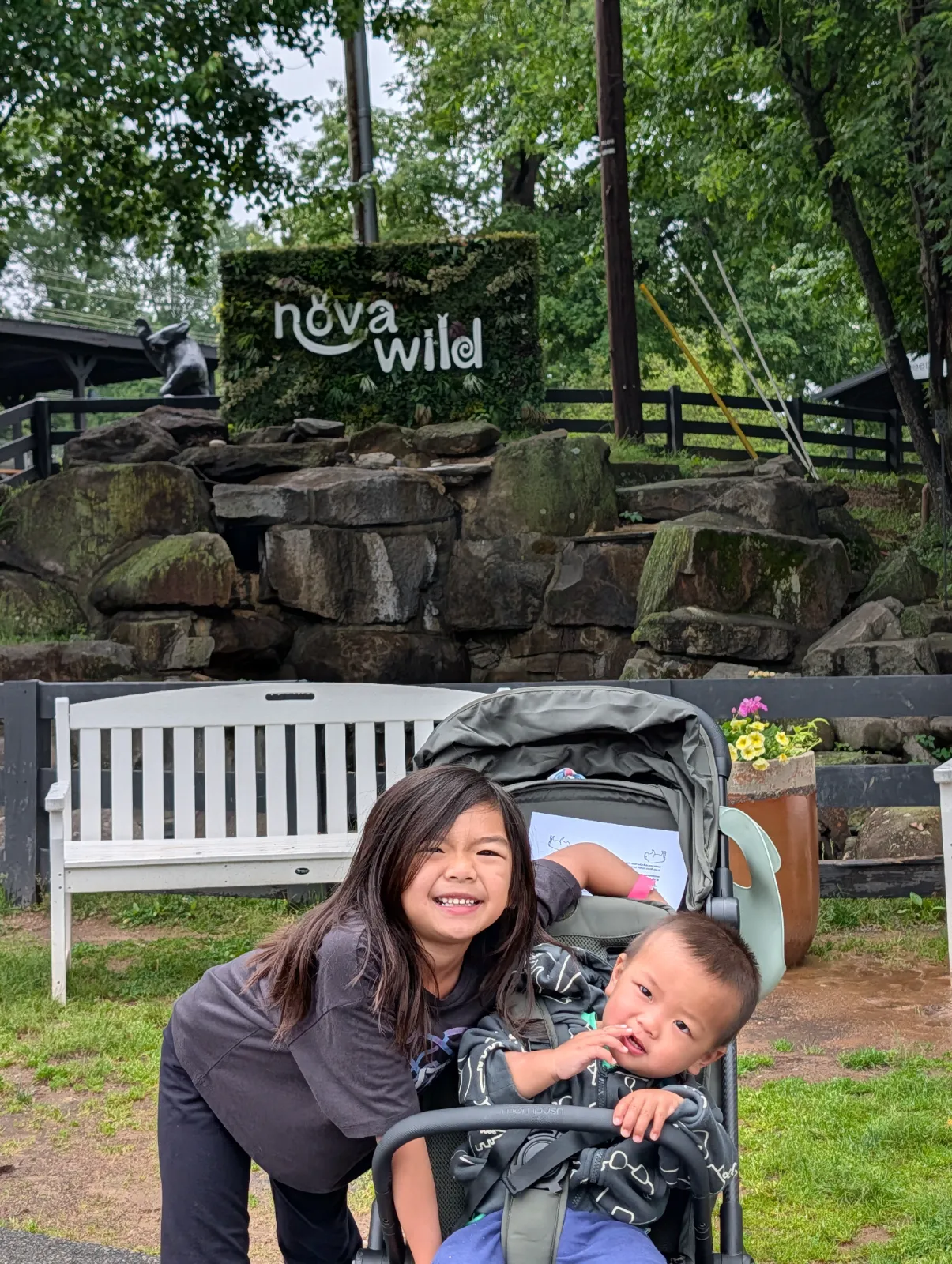 Charlotte smiling with Parker in the stroller at Nova Wild surrounded by greenery