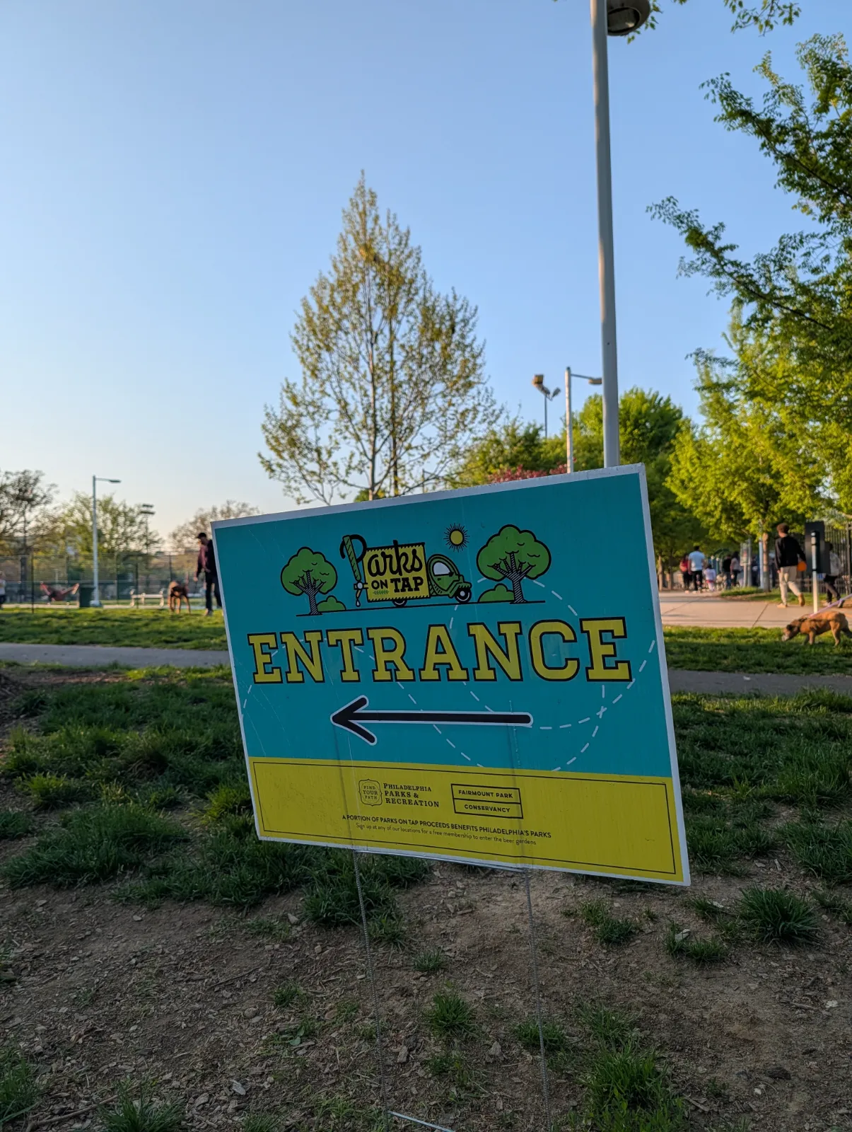 Parks on Tap entrance sign at Columbus Square surrounded by greenery