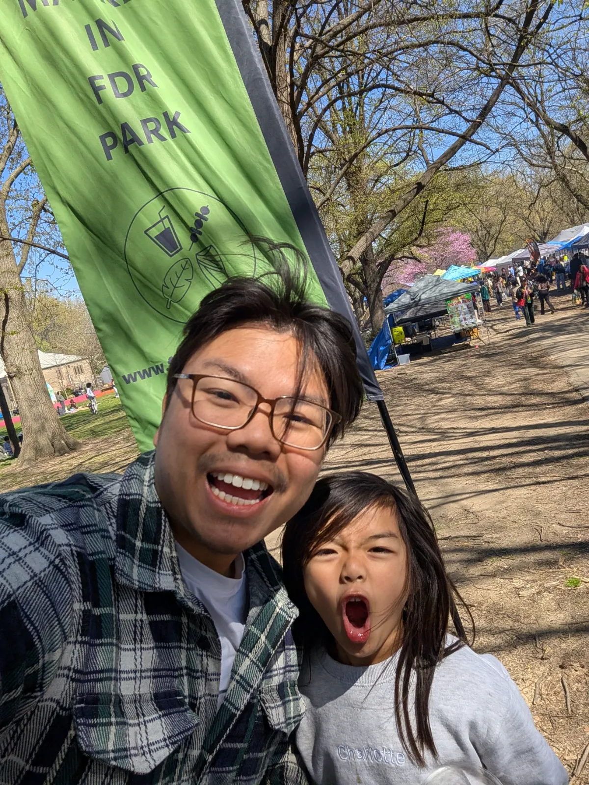 Family selfie in front of the FDR Southeast Asian Market banner entrance