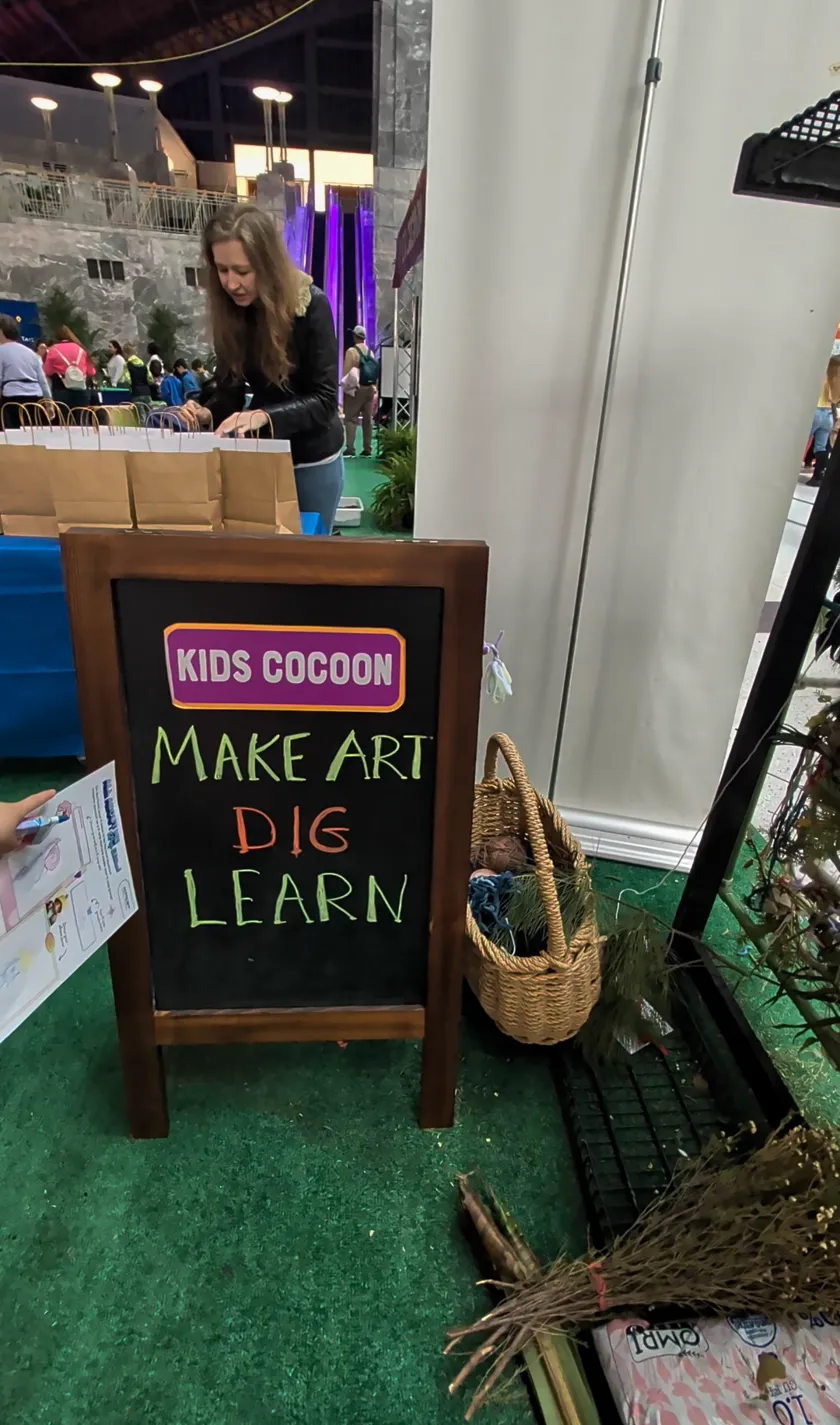 Kids Cocoon chalkboard sign reading Make Art, Dig, Learn at the Philly Flower Show