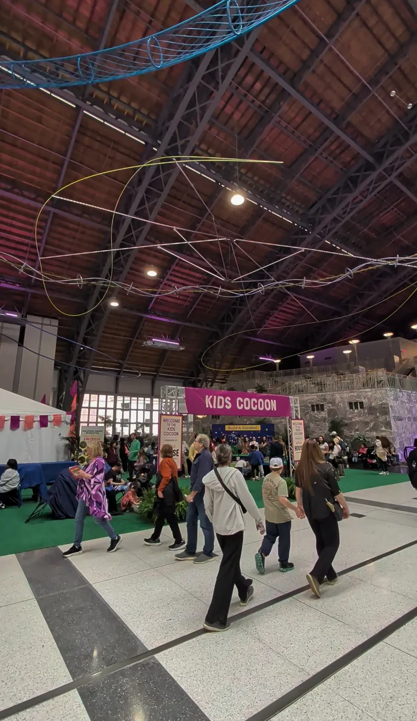 Wide view of the Kids Cocoon area in the Grand Hall with crowds walking through
