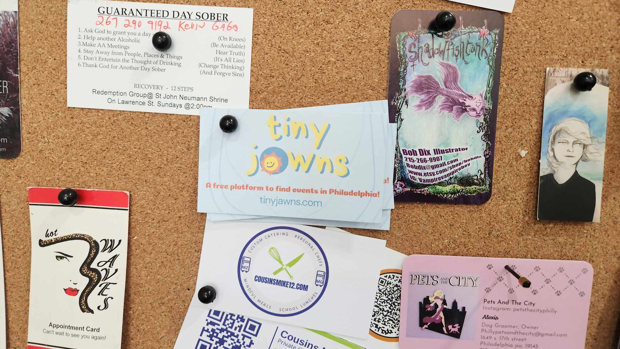 TinyJawns business card pinned to a community bulletin board